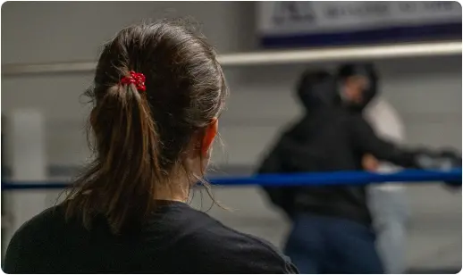 Backside head of girl watching boxing ring fight